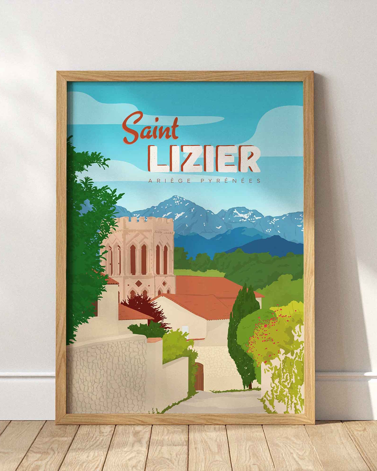 Affiche de la cité de Saint-Lizier encadrée en bois clair, posée au sol contre un mur blanc épuré avec des ombres de fenêtres.