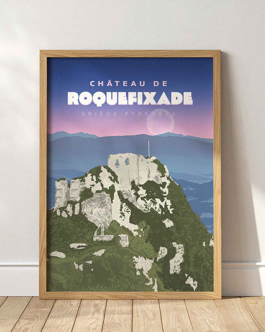 Affiche du château de Roquefixade encadrée en bois clair, posée au sol contre un mur blanc avec des ombres de fenêtres.