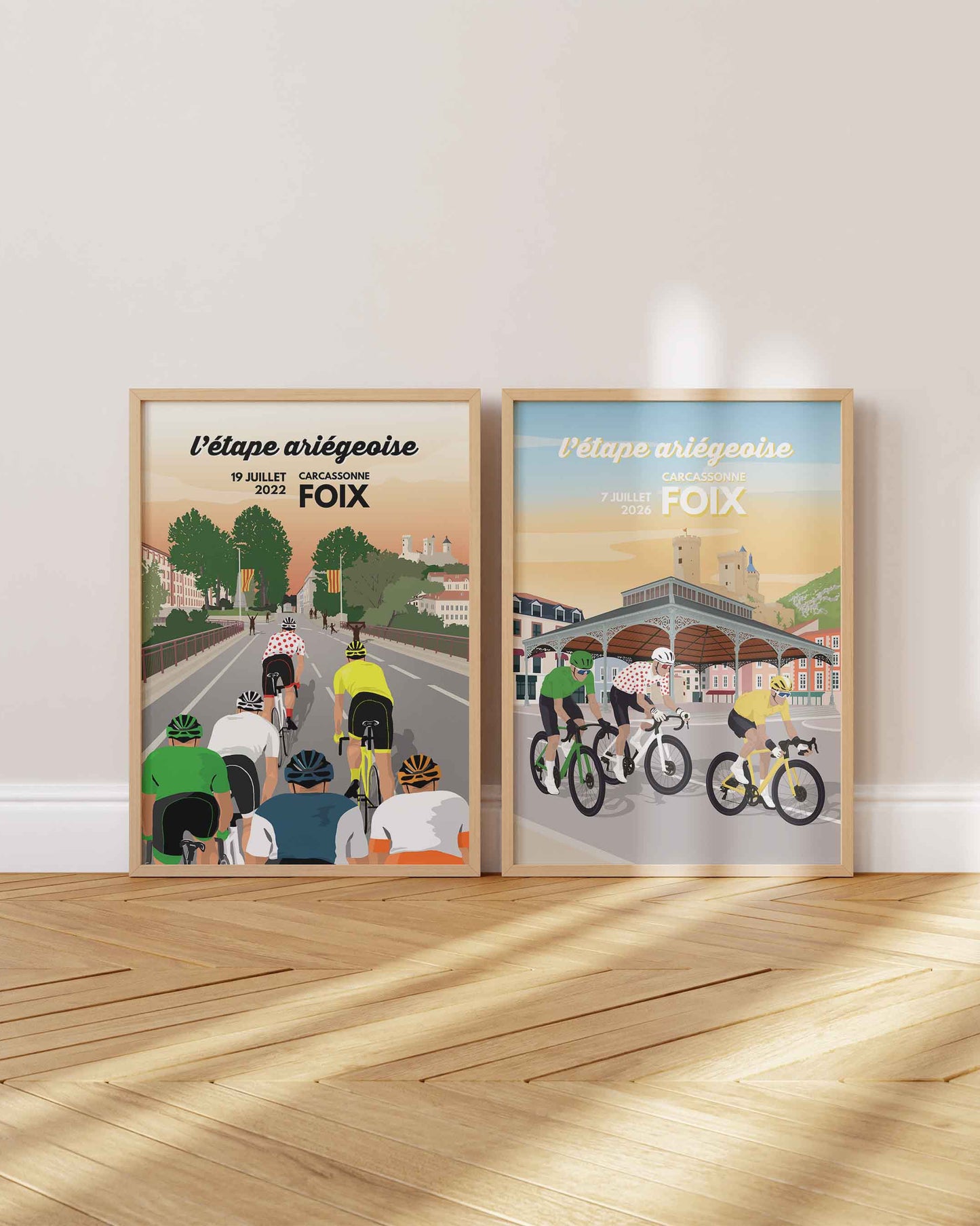 Pack duo d'affiches cyclisme Foix : les étapes ariégeoises de 2022 et 2026 réunies dans deux cadres en bois clair au pied d'un mur blanc.