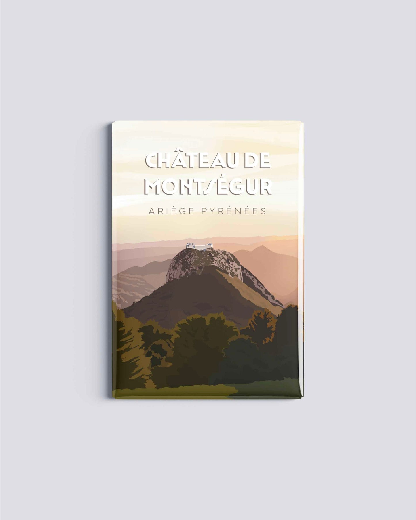 Magnet rectangulaire avec une illustration du château de Montségur perché sur son sommet rocheux sous un ciel de fin de journée en Ariège.