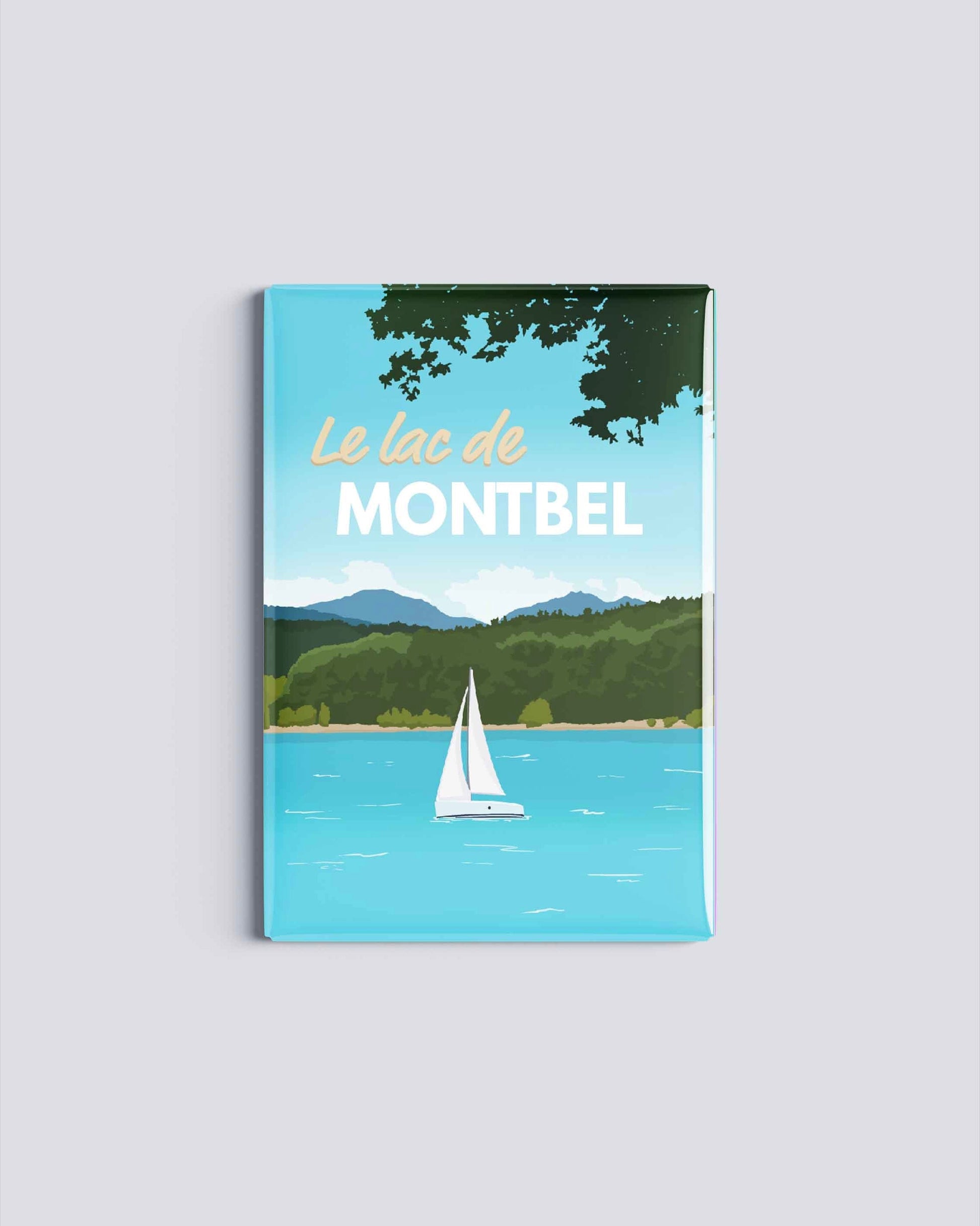Magnet rectangulaire avec une illustration du lac de Montbel montrant un voilier blanc sur une eau turquoise entourée de forêts et de montagnes en Ariège.
