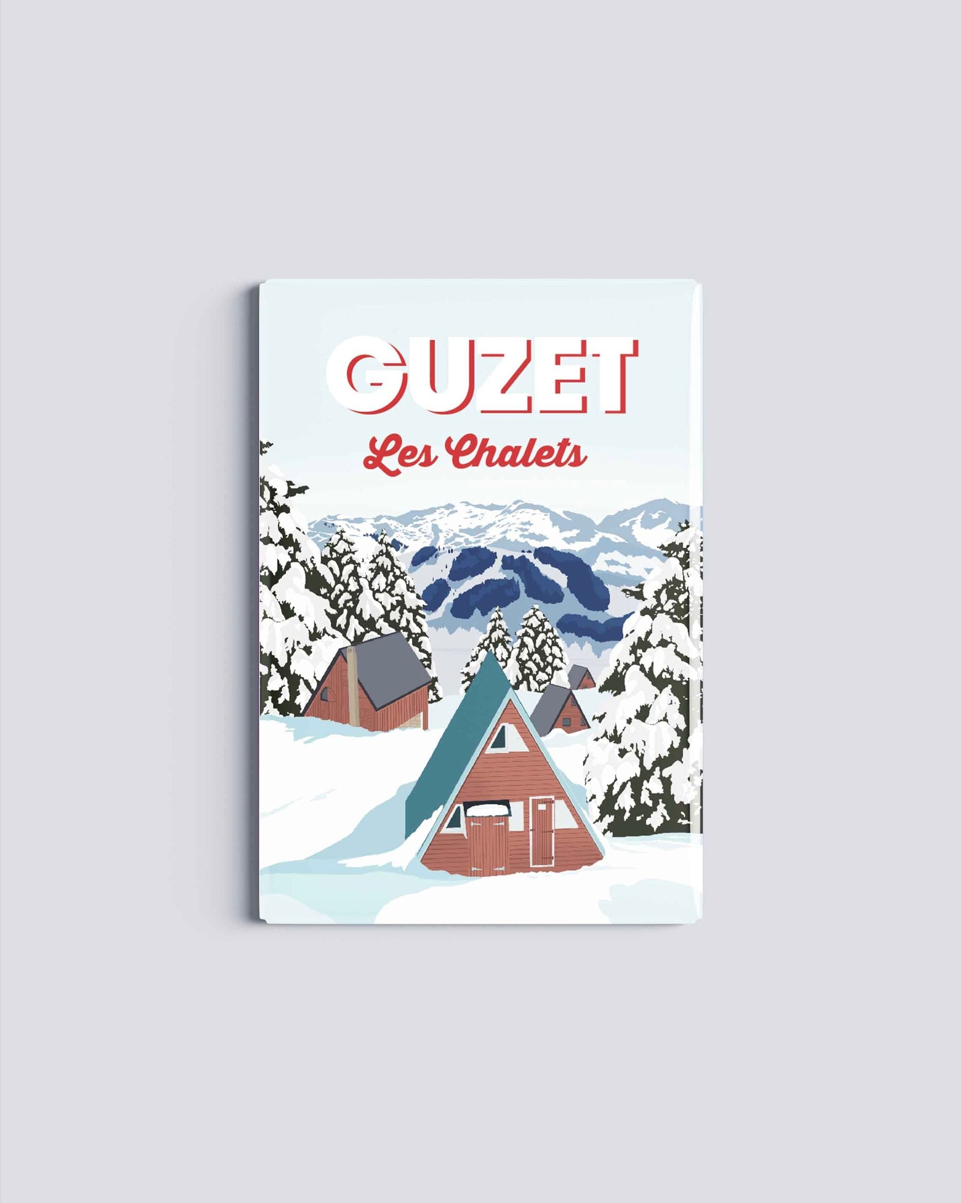 Magnet rectangulaire avec une illustration de la station de Guzet montrant les chalets enneigés et les sapins sous la neige en Ariège.