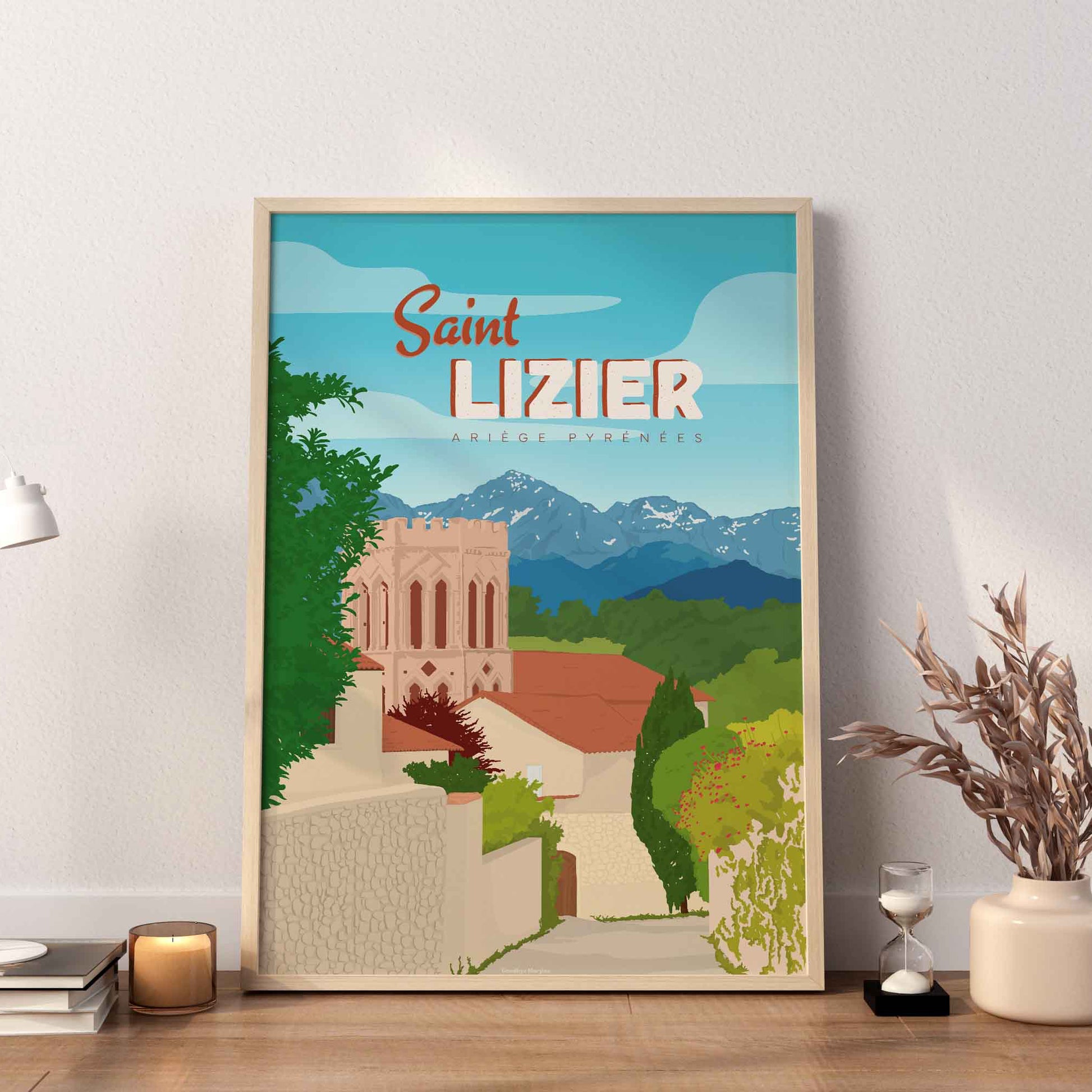 Affiche de Saint-Lizier exposée dans un cadre en bois sur une étagère, accompagnée d'une bougie et d'un vase de fleurs séchées dans une ambiance douce.