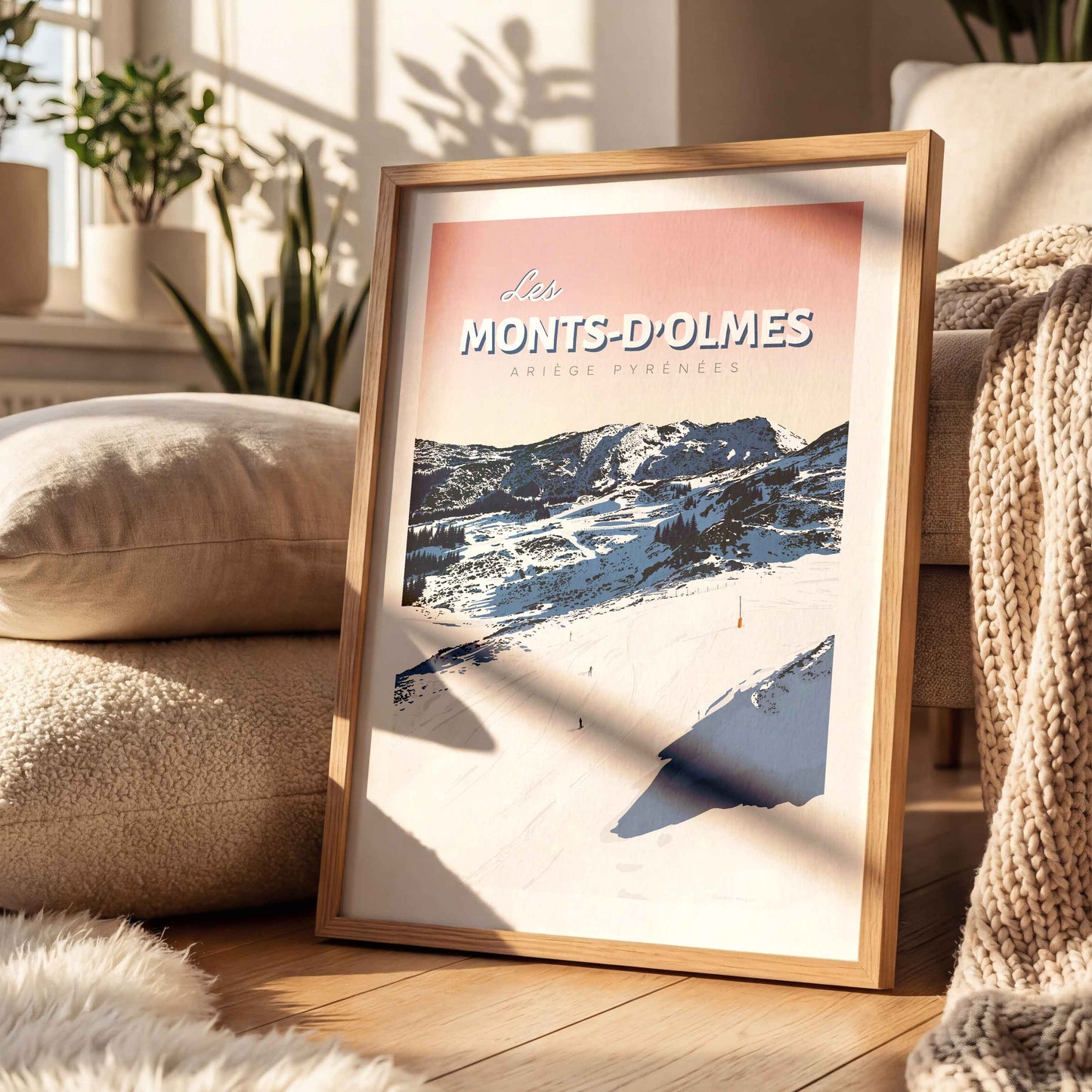 Affiche décorative des Monts-d’Olmes dans un cadre en bois, posée sur un tapis moelleux dans un salon chaleureux et lumineux.
